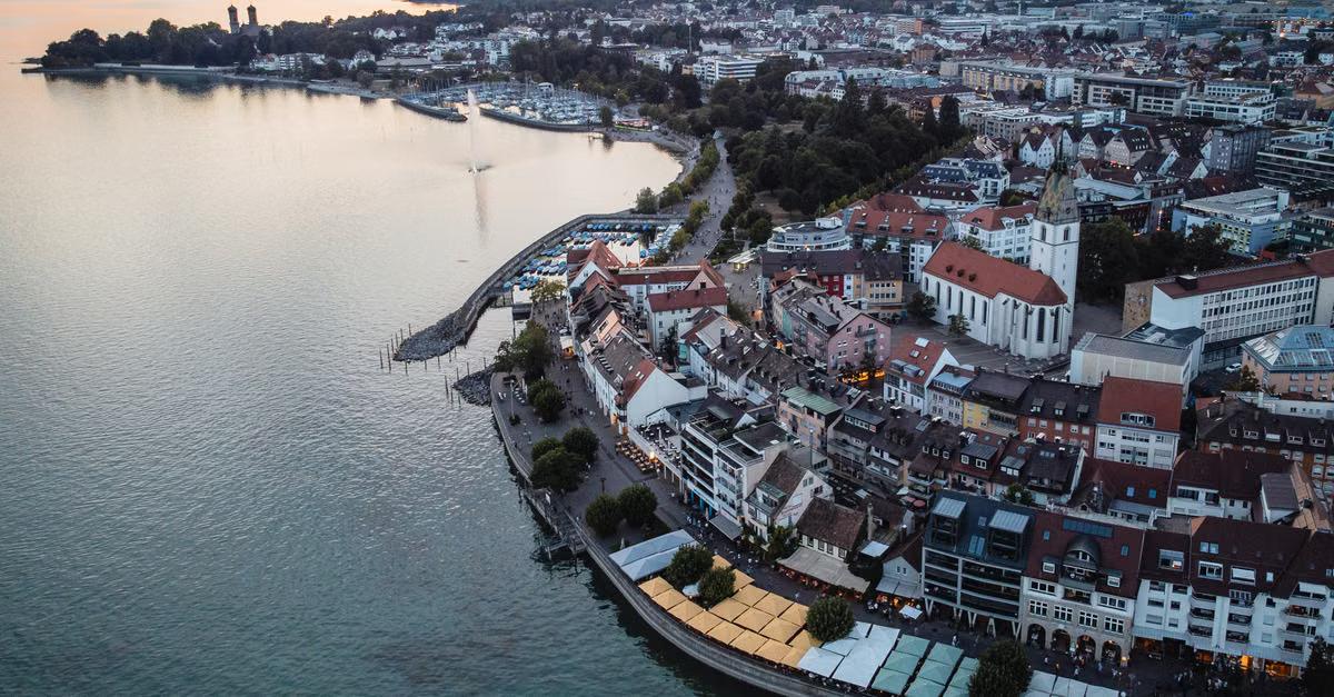 Luftaufnahme von Friedrichshafen mit Uferpromenade, Stadt und Bodensee im Abendlicht